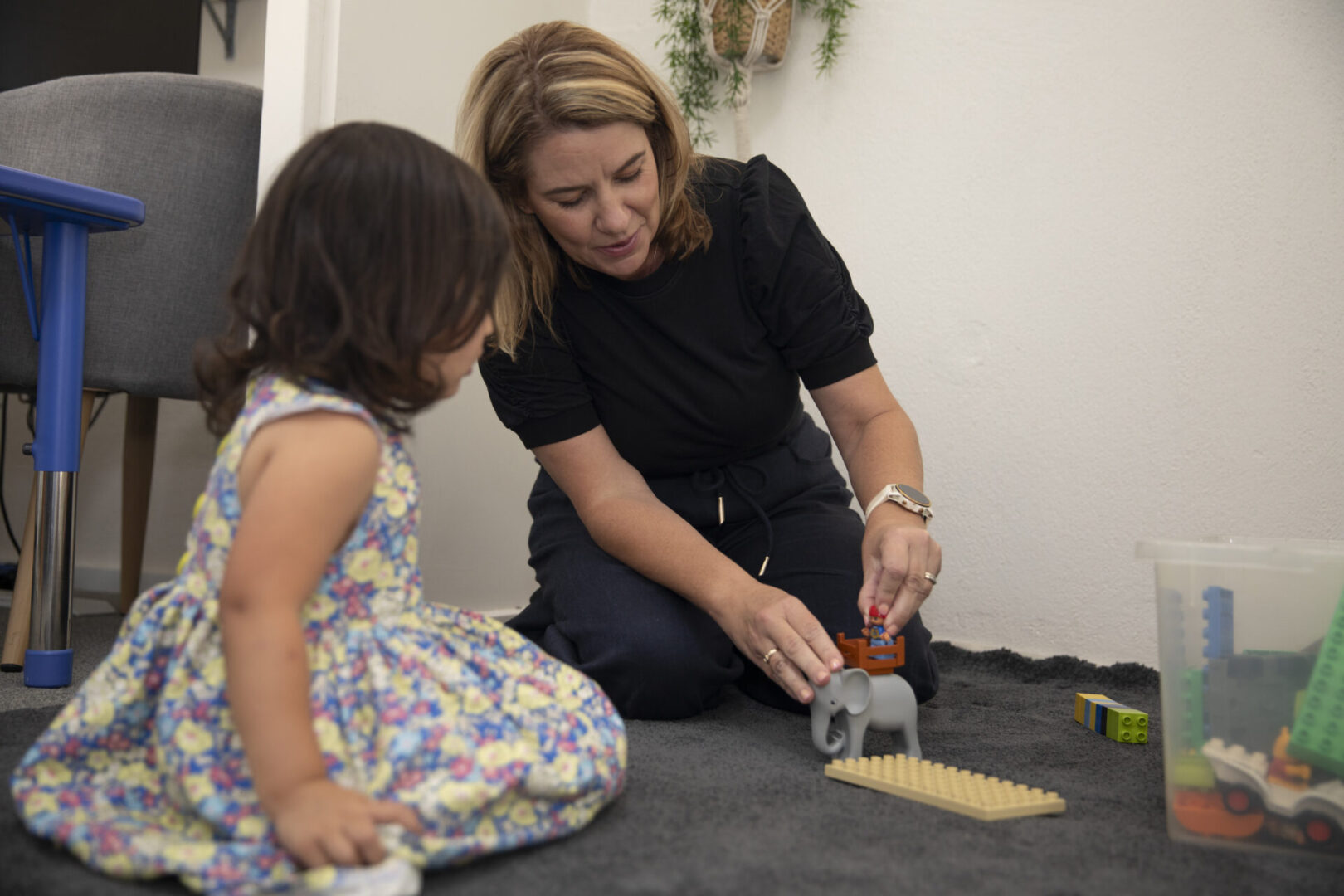 Speech pathologist with client playing on the floor